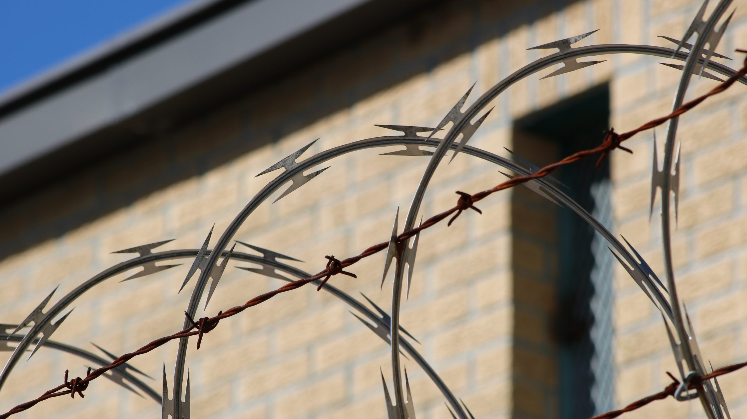 Close up of barbed wire along the top of a fence at a correctional institution