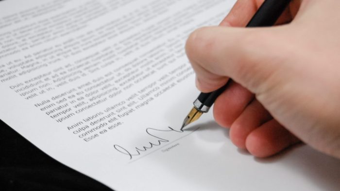 Close up of a hand signing a document